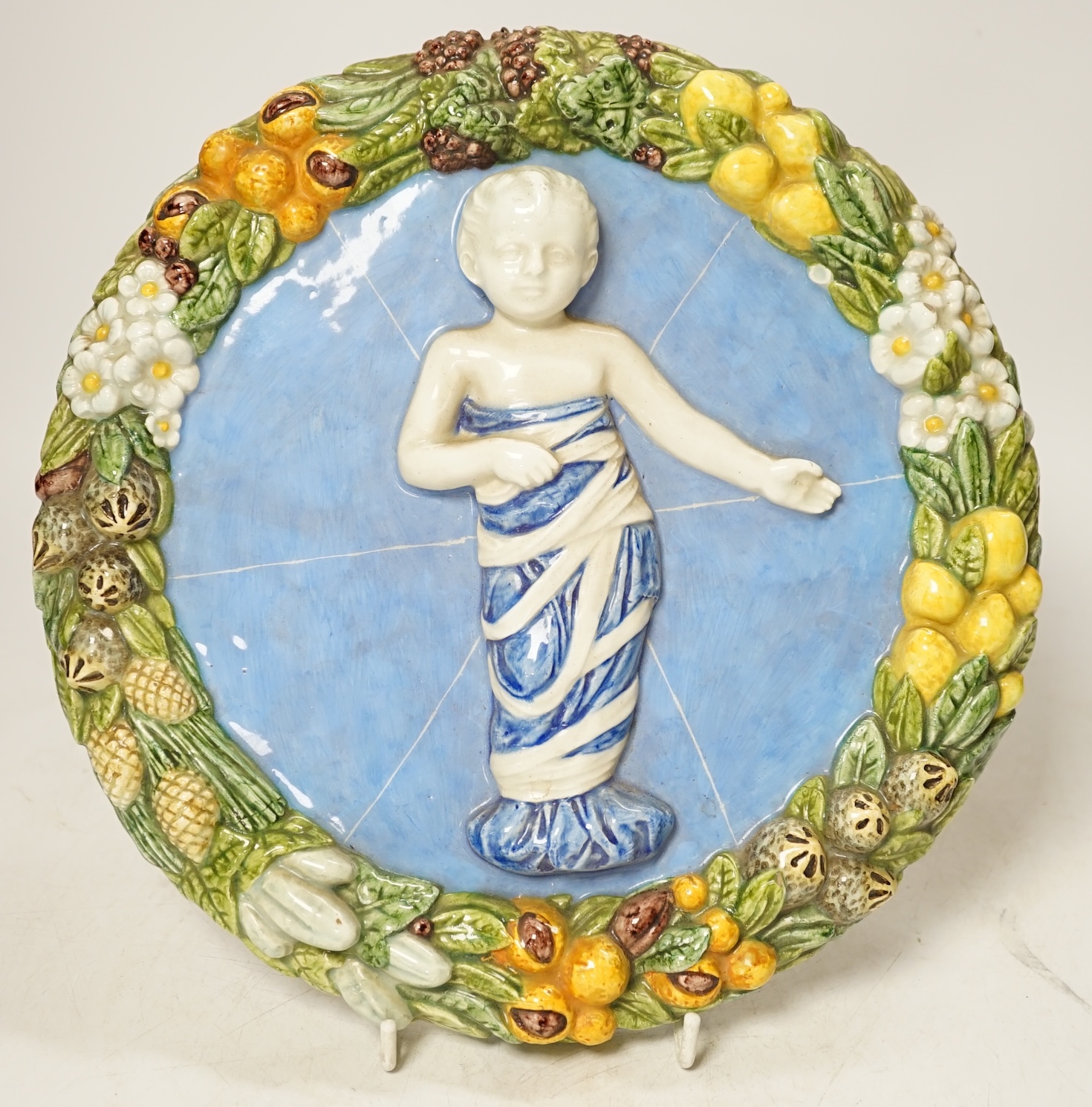 A Della Robbia style circular maiolica plaque, 26cm diameter. Condition - good.